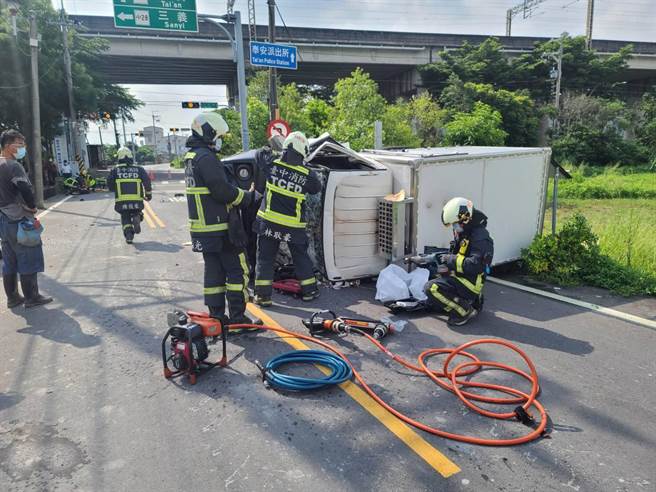 小貨車失控撞擊電線桿，車頭嚴重變形，消防人員協助脫困。（台中市消防局提供／陳淑娥台中傳真）