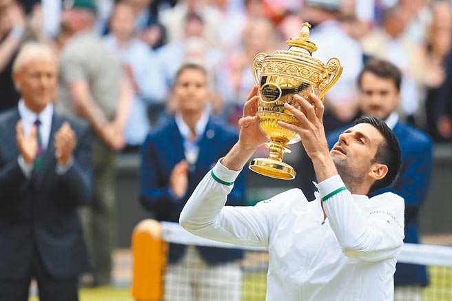 乔柯维奇高举温布顿男单冠军奖杯。（路透）