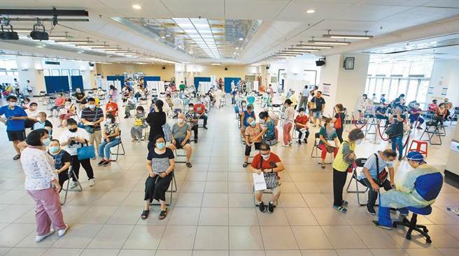 疫苗覆盖率採剂次人口比 蓝委：数字游戏骗国人。图为三重综合体育馆的注射站内，医护人员为民眾接种。（范扬光摄）