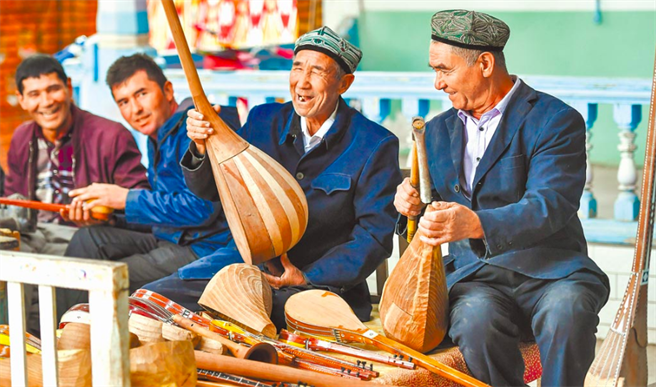 图为新疆疏附县维族老人制作传统乐器。（中新社）