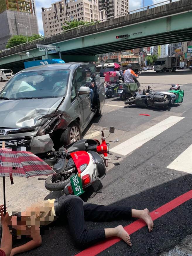 暖心！女骑士被撞后倒地，大热天，柏油路热烫，民眾立即帮她撑伞，等待救护车。（记者爆料网提供／卢金足台中传真）