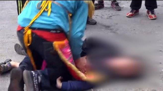 男童倒在地上挣扎，乩童仍不罢手。（截图自网路）