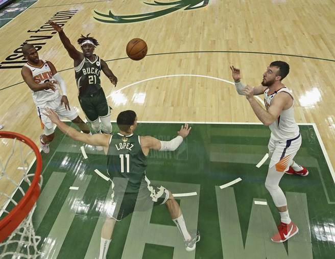 太阳后卫保罗(左)传球给篮下的队友，攻击公鹿禁区。（美联社资料照）