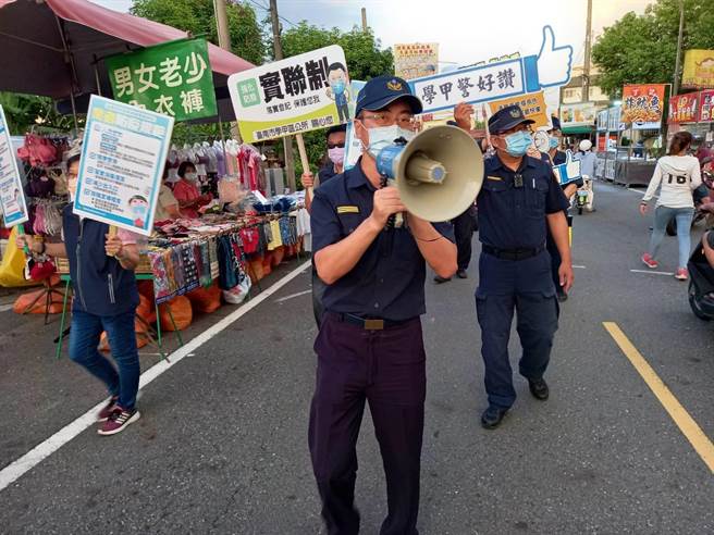 學甲警分局長翁誌宏（中）更拿著大聲公，沿路提醒攤商和民眾遵守防疫規定。（讀者提供／張毓翎台南傳真）