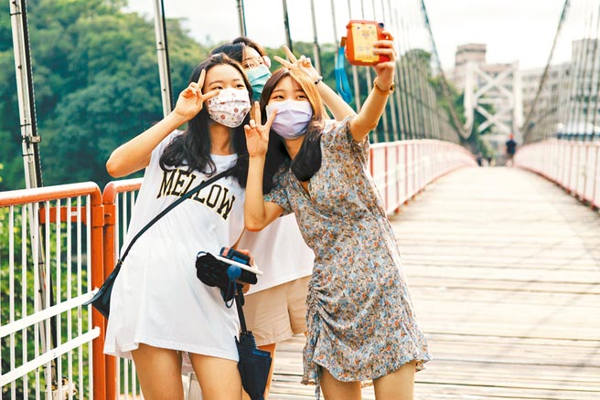 7月13日正式微解封，封闭许久的国家公园、风景区、观光旅游区重新开放，碧潭风景区有民眾开心的在吊桥上拍照留念。（郭吉铨摄）