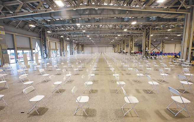 为扩大疫苗普及率，北市政府14日启用在花博争艳馆的大型疫苗接种站，预计每天可为14000多人施打疫苗。（范扬光摄）