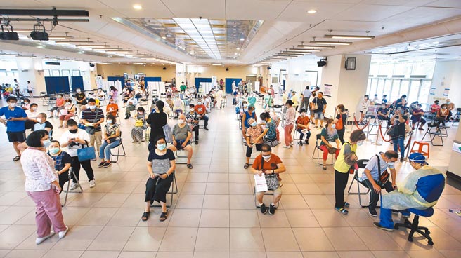 时力痛批第2类「中央及地方政府防疫人员」预估人数一再膨胀，要求执政党说明。图为新北市三重综合体育馆的注射站内，医护人员为67岁以上、原住民57岁以上不限户籍者施打莫德纳疫苗。（范扬光摄）