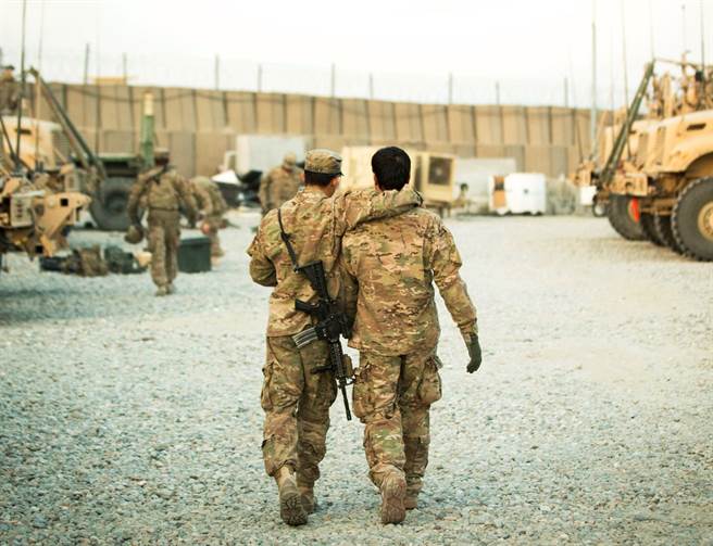 美国政府14日宣布，将自7月最后一周开始撤离在过去20年阿富汗战争中，帮助过美军的阿富汗翻译等无名英雄。图为美军与一名阿富汗翻译人员的背影画面。（资料照／路透社）