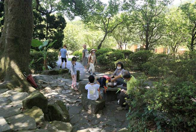 中央氣象局表示，15日天氣高溫炎熱，全台最高溫出現在新北市五股測站達38度，陽明山國家公園旅遊的民眾在茂密的樹蔭下休息。（張鎧乙攝）
