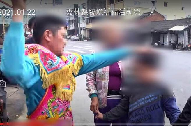 影片拍到乩童重拳打一名男童的肚子，男童的长辈在一旁观看并未拒绝。（截图自网路）