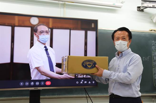 嘉义县长翁章梁（右）从慈济慈善事业基金会执行长顏博文手中接下安心生活箱。（嘉县政府提供／张亦惠嘉县传真）