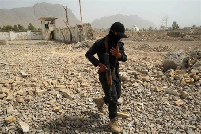 阿富汗安全部队人员走在南部坎达哈省一处爆炸袭击现场。（新华社照片）