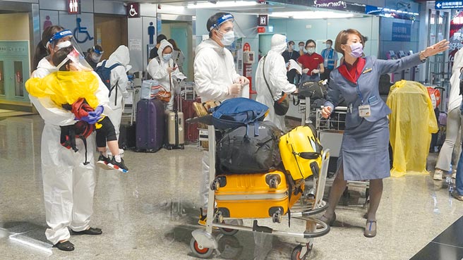 台湾5月中疫情爆发后，赴大陆民眾在隔离期间被验出确诊人数有增加趋势。图为桃园机场旅客穿着防护衣和戴着面罩的画面。（中新社）