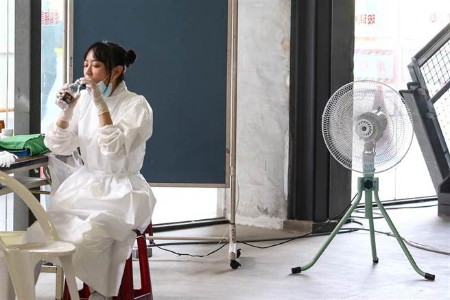 台北市政府与三军总医院在台北市网球中心合办施打疫苗，16日改打AZ疫苗，陆续有民眾前往接种。天气炎热，护理师趁着空挡赶快补充水分。（邓博仁摄）