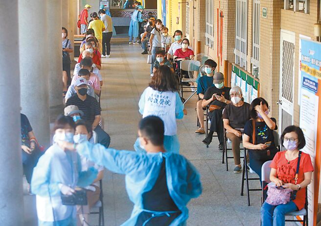 全台陆续出现民眾闯接种站企图混打疫苗乱象。图为台北市接种站民眾排队等待（示意图与新闻事件无关）。（王英豪摄）