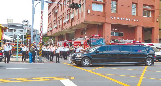陈志帆灵车经过彰化县消防局东区分队，同事列队举手致敬，消防车鸣笛，相送最后一程。（吴敏菁摄）