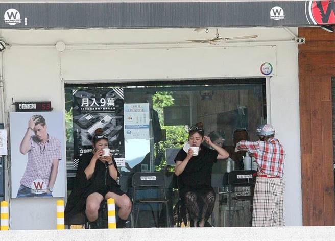 新冠肺炎本土确诊数首度降到个位数，面对微解封后第一个周末，中央流行疫情指挥中心指挥官陈时中也公布出游饮食微解封，如果民眾自行开车外出，同车者为同住家人可以饮食，非同住家人或不认识者还是要分别戴口罩，图为两位髮型设计师在店后方享受甜品。（张铠乙摄）

