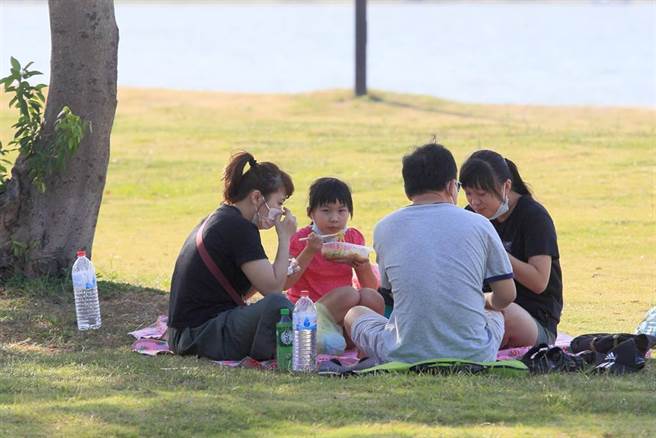 新冠肺炎本土确诊数首度降到个位数，面对微解封后第一个周末，中央流行疫情指挥中心指挥官陈时中也公布出游饮食微解封，如果民眾自行开车外出，同车者为同住家人可以饮食，非同住家人或不认识者还是要分别戴口罩，图为民眾17日在新北八里左岸户外野餐。（张铠乙摄）
