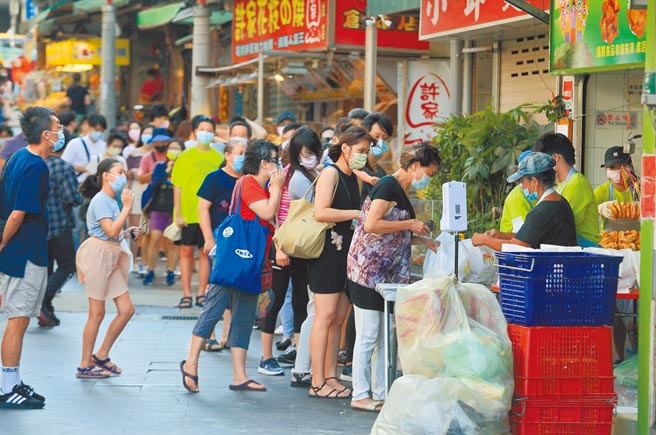 微解封后第一个周末，新北八里渡船头老街的双胞胎名店涌现排队人潮。（张铠乙摄）
