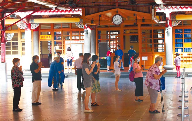 台北市行天宮17日開放參拜，採取實聯制和量體溫等防疫措施，定點跟定點間要有1.5公尺以上距離，只可雙手合十拜拜，收驚、擲茭、抽籤等暫不開放，且人流控制不超過99人，不少虔誠信徒一早就前往拜拜祈求平安。（趙雙傑攝）