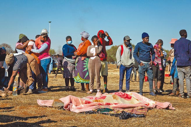 南非因前总统祖马被捕入狱引发动乱，迄今已造成212人死亡。图为7月14日，一些遇难者家属在约翰尼斯堡现场神色悲痛。（新华社）