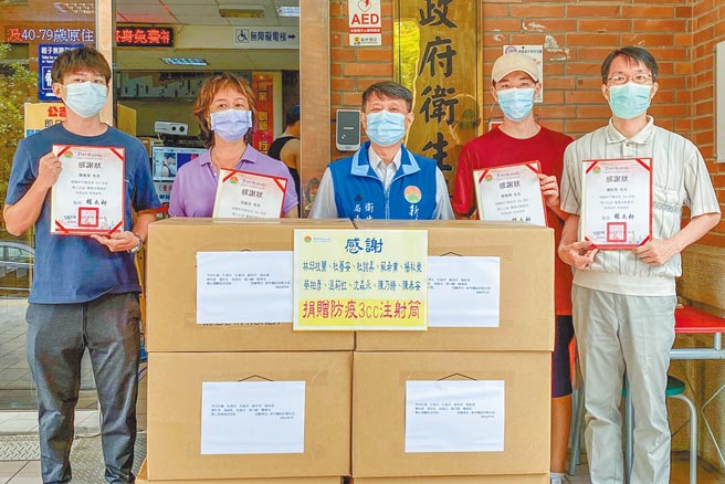 新竹縣愛心民眾揪團10人集資購買1萬4400支3cc注射空針，衛生局長殷東成（中）代表接受。（新竹縣政府提供／羅浚濱新竹傳真）