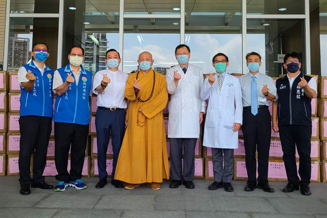 立委林思銘（右）與慈善團體在新竹台大分院生醫院區捐贈防疫防護衣。（羅浚濱攝）