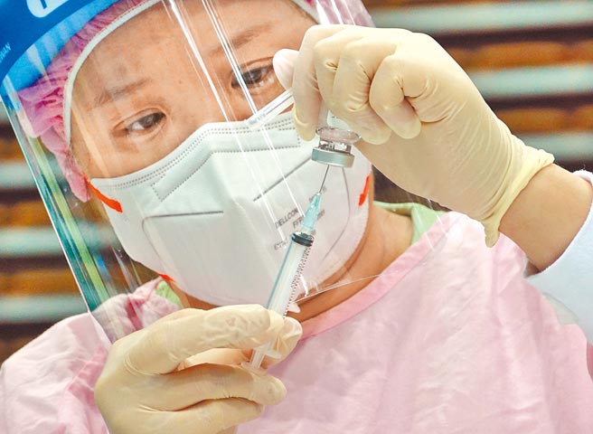 打疫苗并非万灵丹！疫情指挥中心昨公布新增3例境外移入个案，其中2例都是分别接种2剂BNT和AZ疫苗后仍然确诊。图为医护人员全神贯注抽取疫苗，不浪费一丝一毫。（本报资料照片）