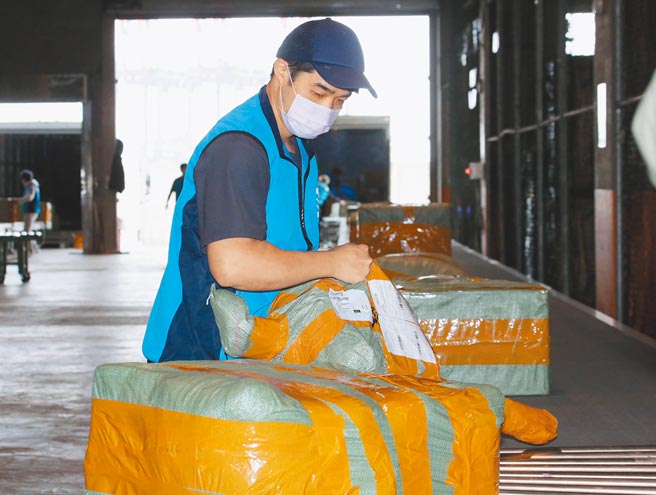 图为台北港内工作人员整理并检查包裹的情形。（本报资料照片）
