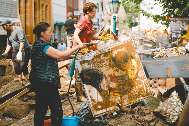 德国西部巴特明斯特艾弗尔镇于洪水肆虐后，一些居民17日在户外整理和清洗污损的物品。德国因洪水死亡人数上升至157人，仍有上千人下落不明。（新华社）