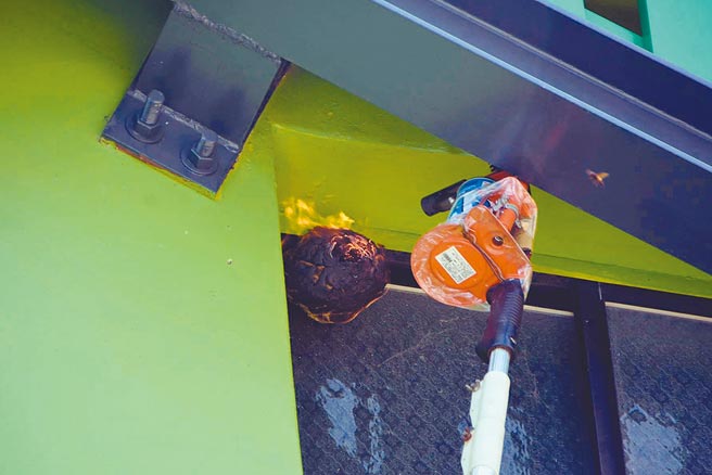 台东县关山镇米国学校外墙出现虎头蜂窝，县府委外厂商人员，以火攻摘除。（民眾提供／庄哲权台东传真）