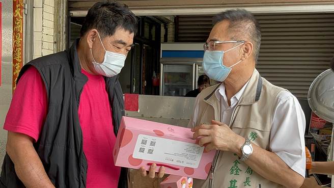 台南市政府勞工局長王鑫基（右）將喜憨兒防疫愛心箱發送給弱勢勞工家庭。（南市勞工局提供／張毓翎台南傳真）