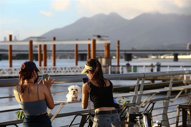 輕颱烟花行進慢、路徑直逼台灣東北角，微解封後20日傍晚許多民眾前往大稻埕賞夕陽。（鄧博仁攝）