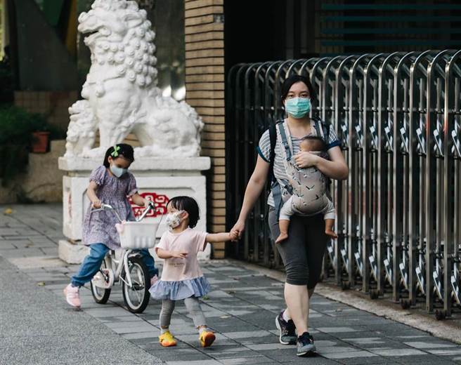 一位家長接送多名孩童。(郭吉銓攝)