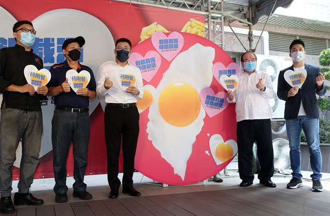 中国国民党21日召开「载飢载渴，伴你挺过。爱心待餐 全台串连」记者会，党主席江启臣（中）偕同秘书长李乾龙（右2）、立委蒋万安（右）及合作店家代表一起拿着心型待用餐的标志，并喊出「一天一万餐，陪你度难关」口号，呼吁更多店家及民眾参与待用餐计画，一同协助经济弱势民眾温饱，也增加提供待用餐爱心店家的收入，让大家携手团结顺利度过疫情下的难关。（刘宗龙摄）