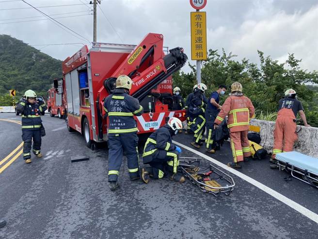 骑士跌落山坡，救难人员正在场救援。（新北市消防局提供）