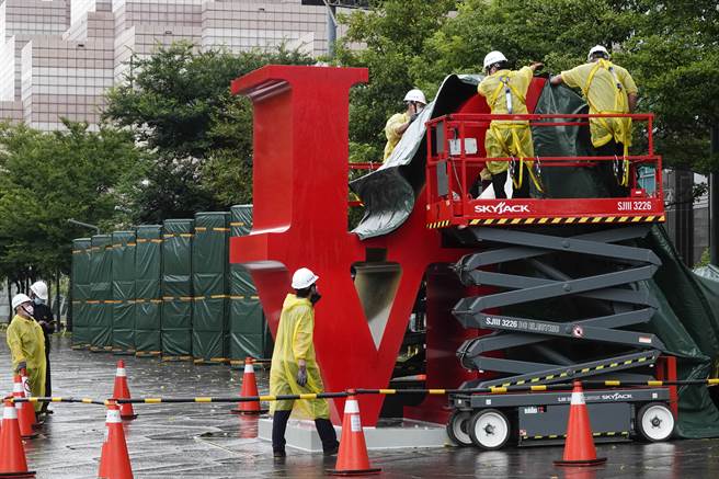 台北101大楼今天派员将大楼广场的「LOVE」艺术装置盖上防水帆布，预先做好防颱措施。(黄子明摄)