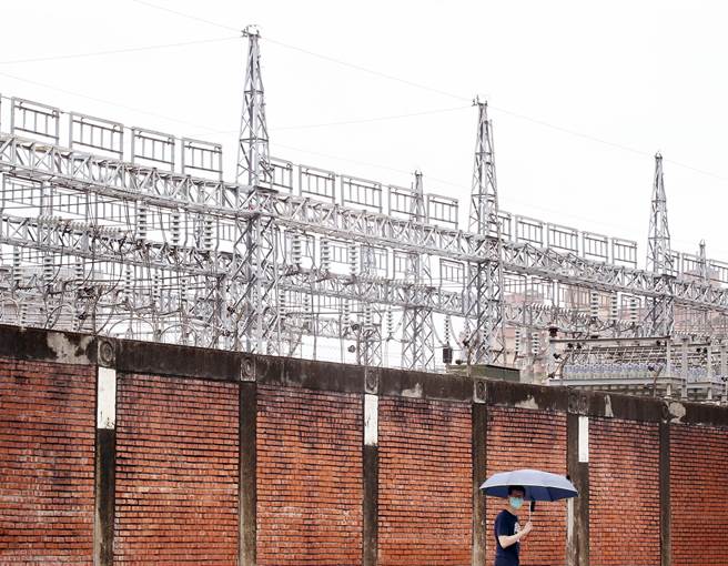 新冠肺炎衝擊民生經濟，行政院22日拍板決定，部分民生用電將直接取消夏季電價計費，以減輕民眾負擔，1位民眾正走過台電萬隆變電所的外圍人行道。（范揚光攝）