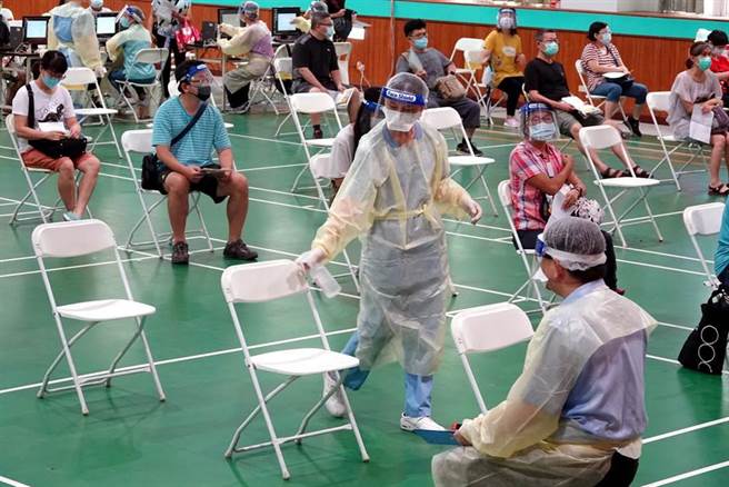 工作人员在接种者离席后立刻上前清消座椅。（黄世麒摄）
