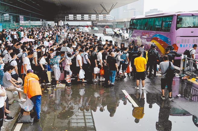 滞留旅客在郑州东站进站口处排队登乘大巴车。（新华社）
