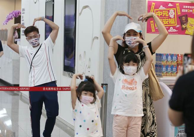 中华奥运代表团19日搭乘2020 东京奥运专案班机前往日本，图为射箭国手雷千莹（左一）与到场加油亲友隔着封锁线，比出爱心动作合照。（资料照）