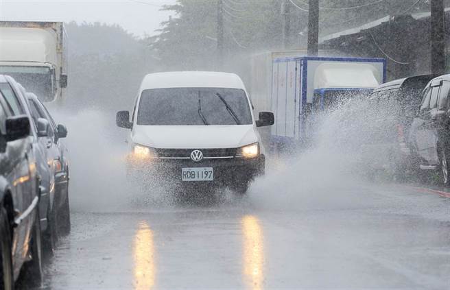 颱风烟花速度加快北转，预计23日晚上8点到24日上午最接近台湾本岛，台北市23日偶有间歇风雨，车辆行经积水处溅起水花。（张铠乙摄）
