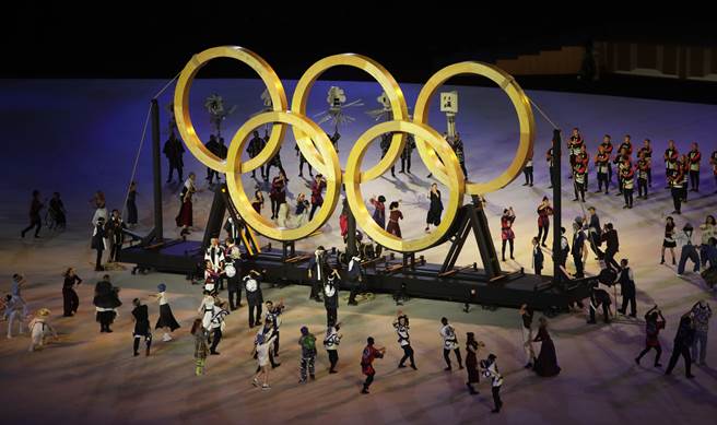 東京奧運開幕式，舞者在巨型五環前表演。(季志翔攝)