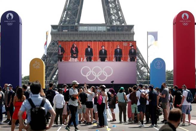 法国首席新冠防疫医疗顾问警告，今年冬季可能出现新的变异病毒株。图为巴黎民眾观看东奥开幕式转播。（图／路透社）