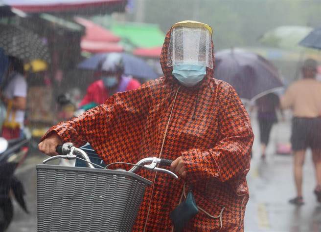 中央气象局24日解除中颱烟花海上颱风警报，但受到外围环流影响，北市出现间歇性大雨，让出门买菜的民眾淋了一身湿。（张铠乙摄）

