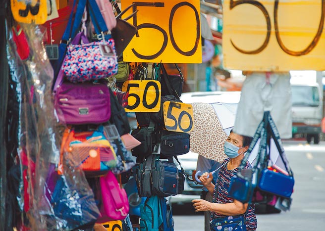 疫情衝击民生，行政院将规画振兴措施，考虑发放振兴券或现金。图为淡水老街23日受疫情及颱风影响，人潮稀落，店家祭出优惠，一名妇人经过不停观望。（罗永铭摄）