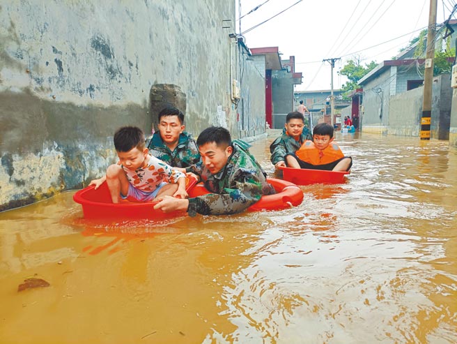 大陆河南多地洪灾，中共解放军出动官兵救援。图为火箭军士兵在河南省新乡市卫辉市用大盆转运被洪水围困的孩童。（中新社）