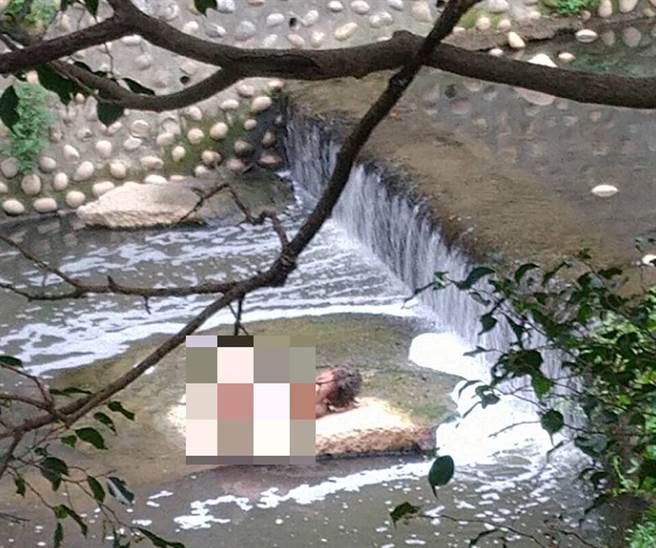 警方获报有名男子一丝不挂躺卧于大排水溪中，因地处偏远、人迹罕至，任凭员警如何呼叫，男子却无动于衷。（民眾提供）