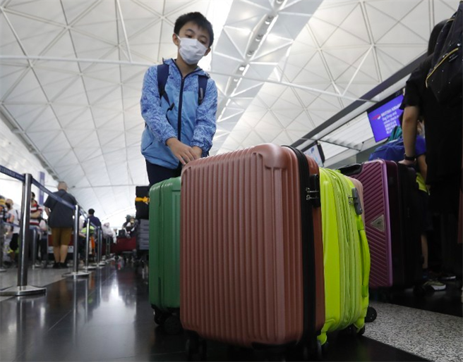 香港大批家庭带着子女离港，触发退学潮。（东网）