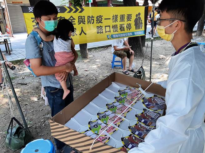 高市府人员在疫苗接种站对民眾发送道安宣导品。（交通局提供／石秀华高雄传真）